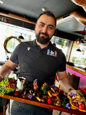 Eieren presenterer en grillplanke i restauranten